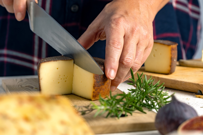 Käse mit dem Messer aufschneiden