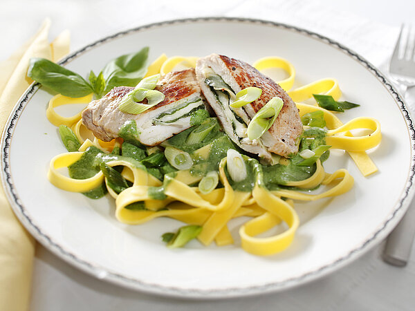 Schweinerückensteaks angerichtet auf Bandnudeln mit Mozarella und Käsesoße